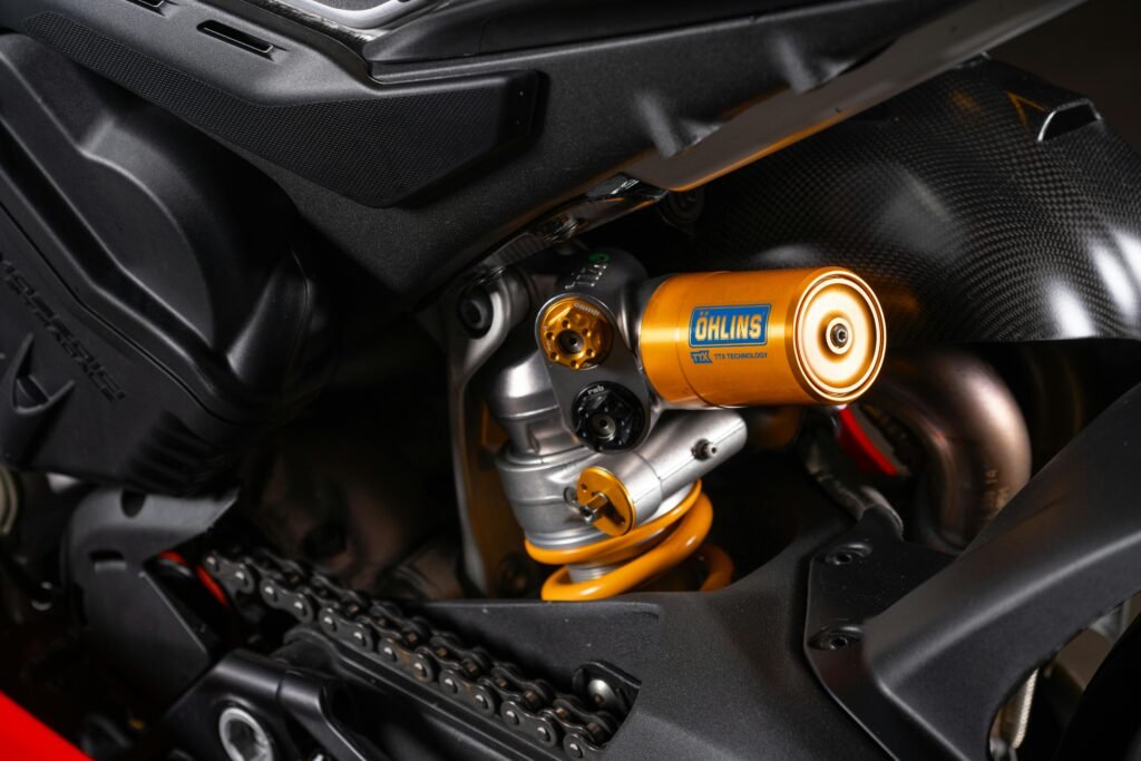 Detailed close-up of the Öhlins suspension on a Ducati Panigale motorcycle showing intricate parts.